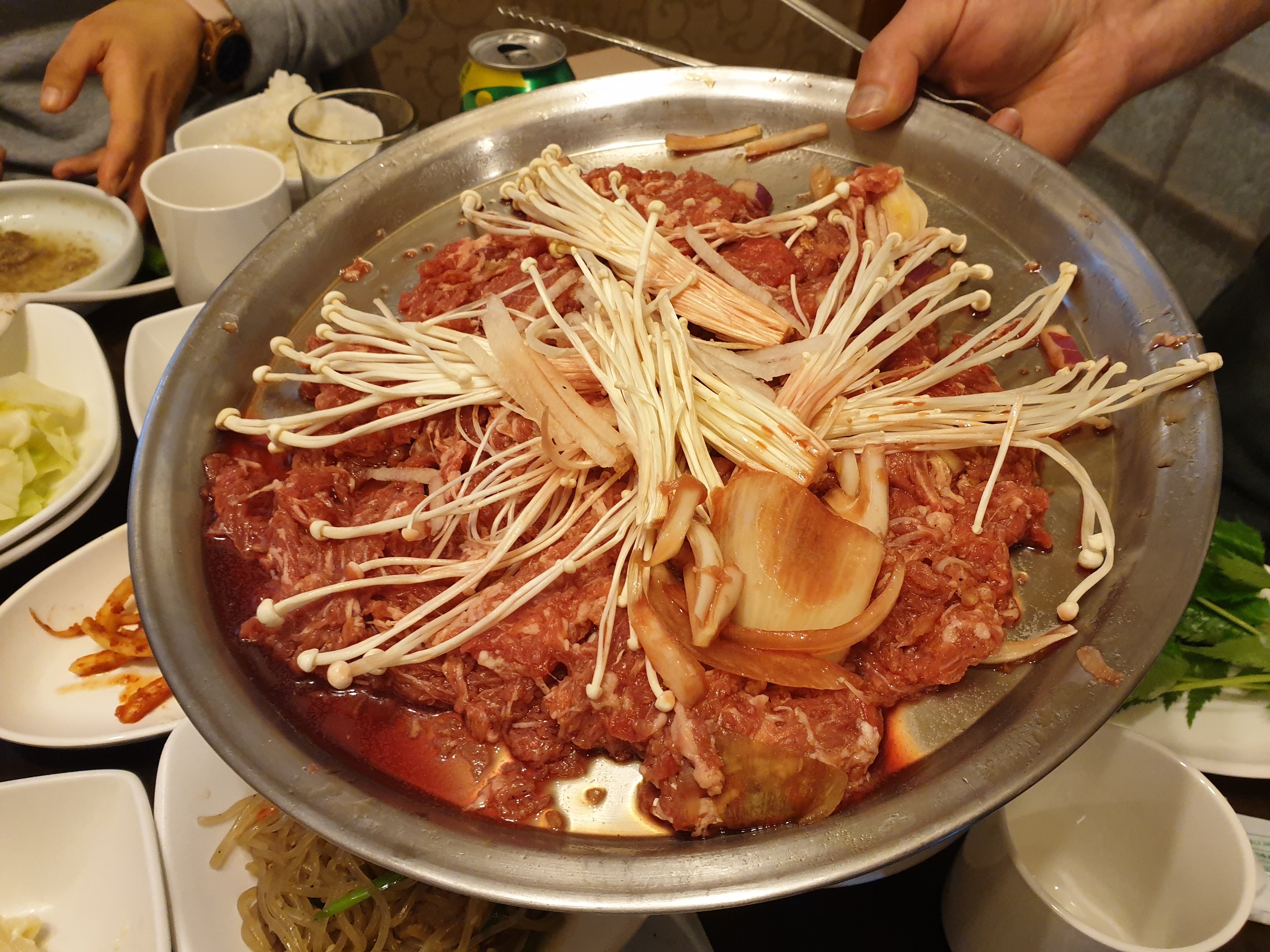 테이블 위에 놓인 불고기 전골 냄비와 쌈채소