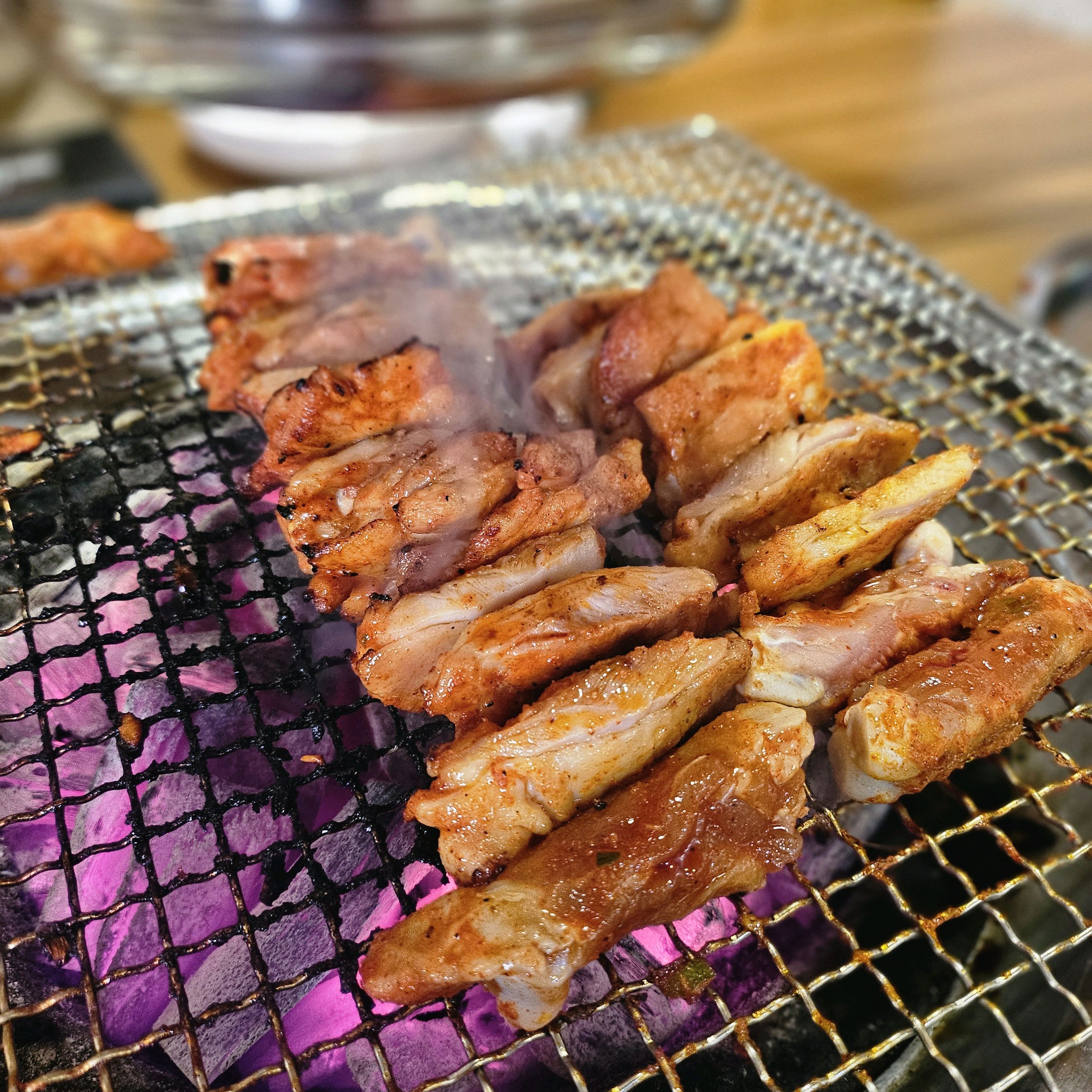 숯불 위에서 익어가고 있는 닭갈비와 닭목살