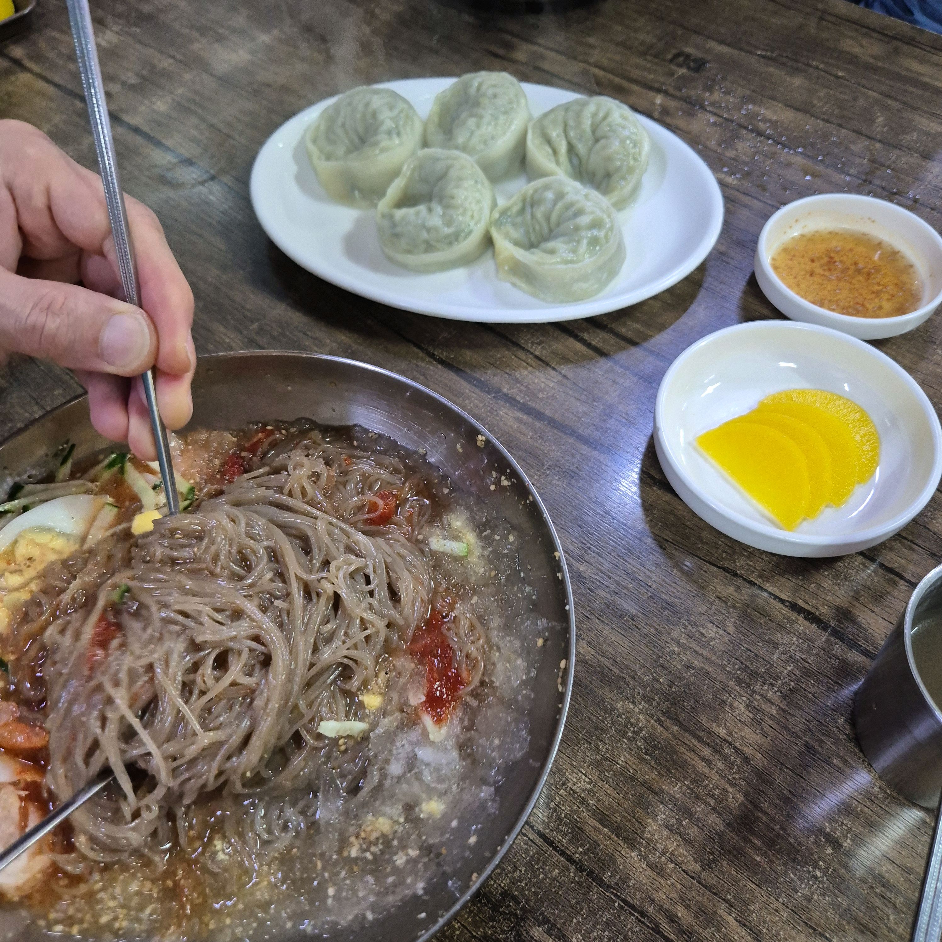 냉면을 덜어내고 있는 모습, 실처럼 가는 면발이 보인다.