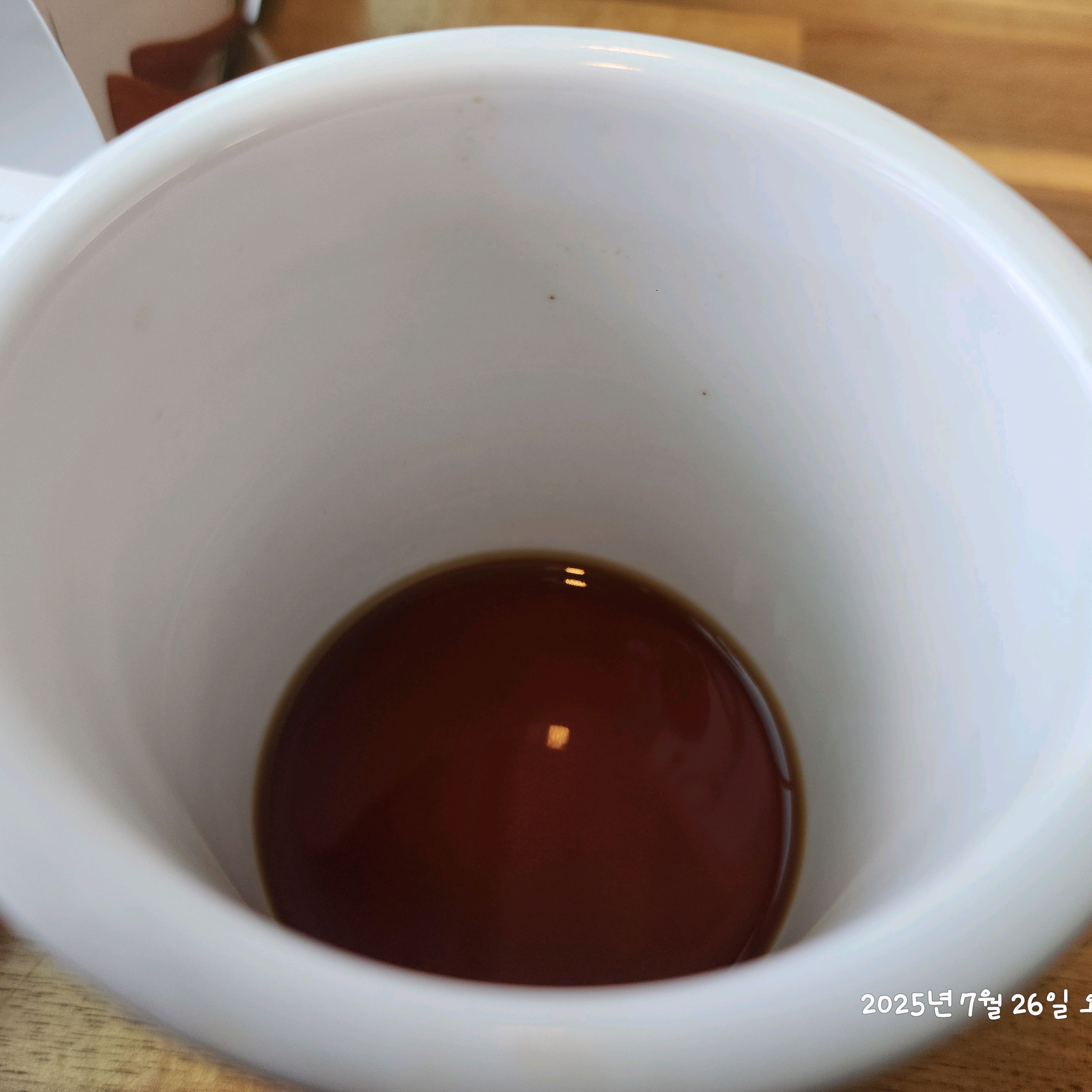 흰색 컵 안에 담긴 검은색 액체 (커피)