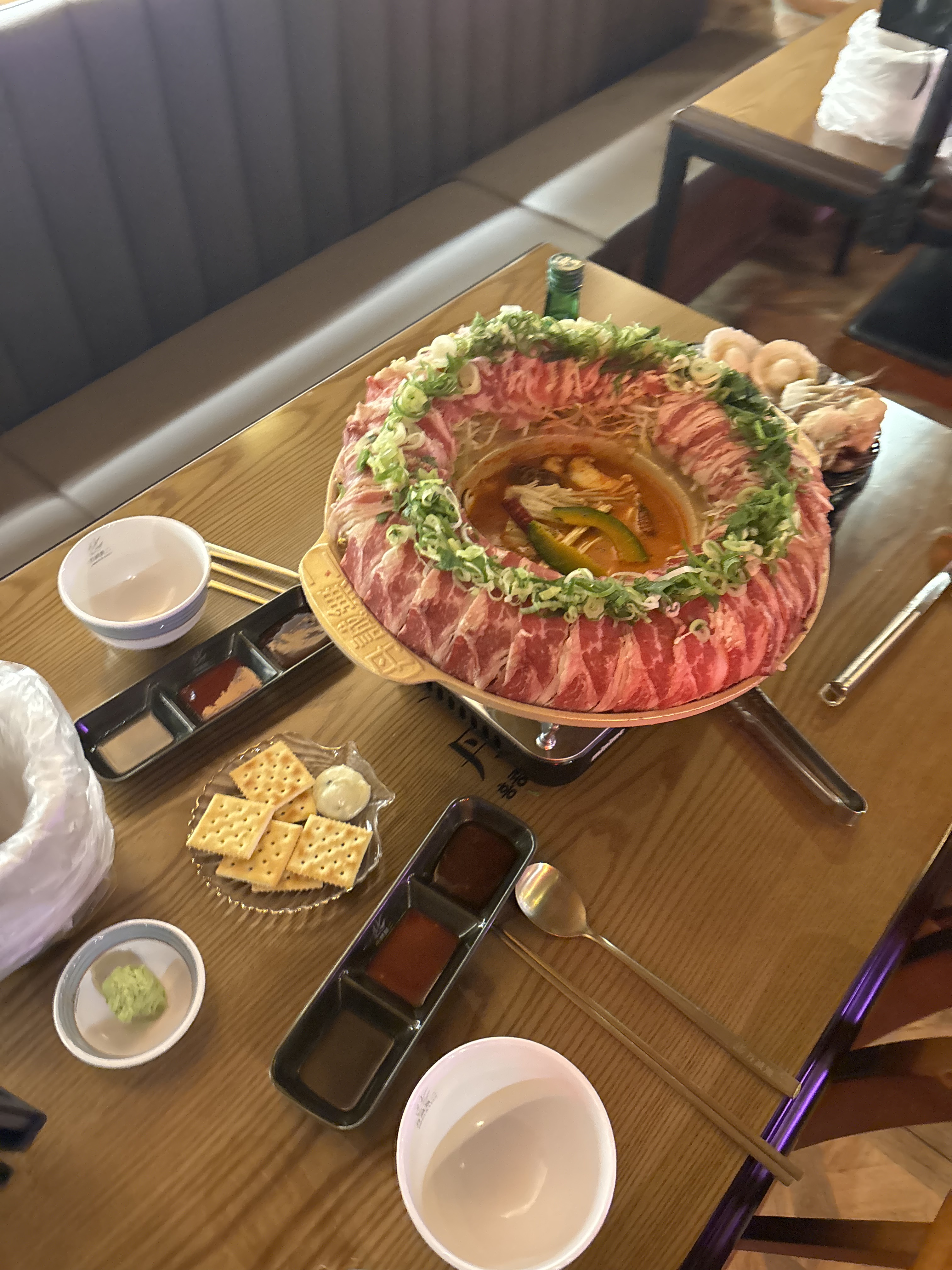 자리 간격이 넉넉해서 여유 있게 앉을 수 있었어요. 테이블 위 소스와 그릇들이 가지런히 정