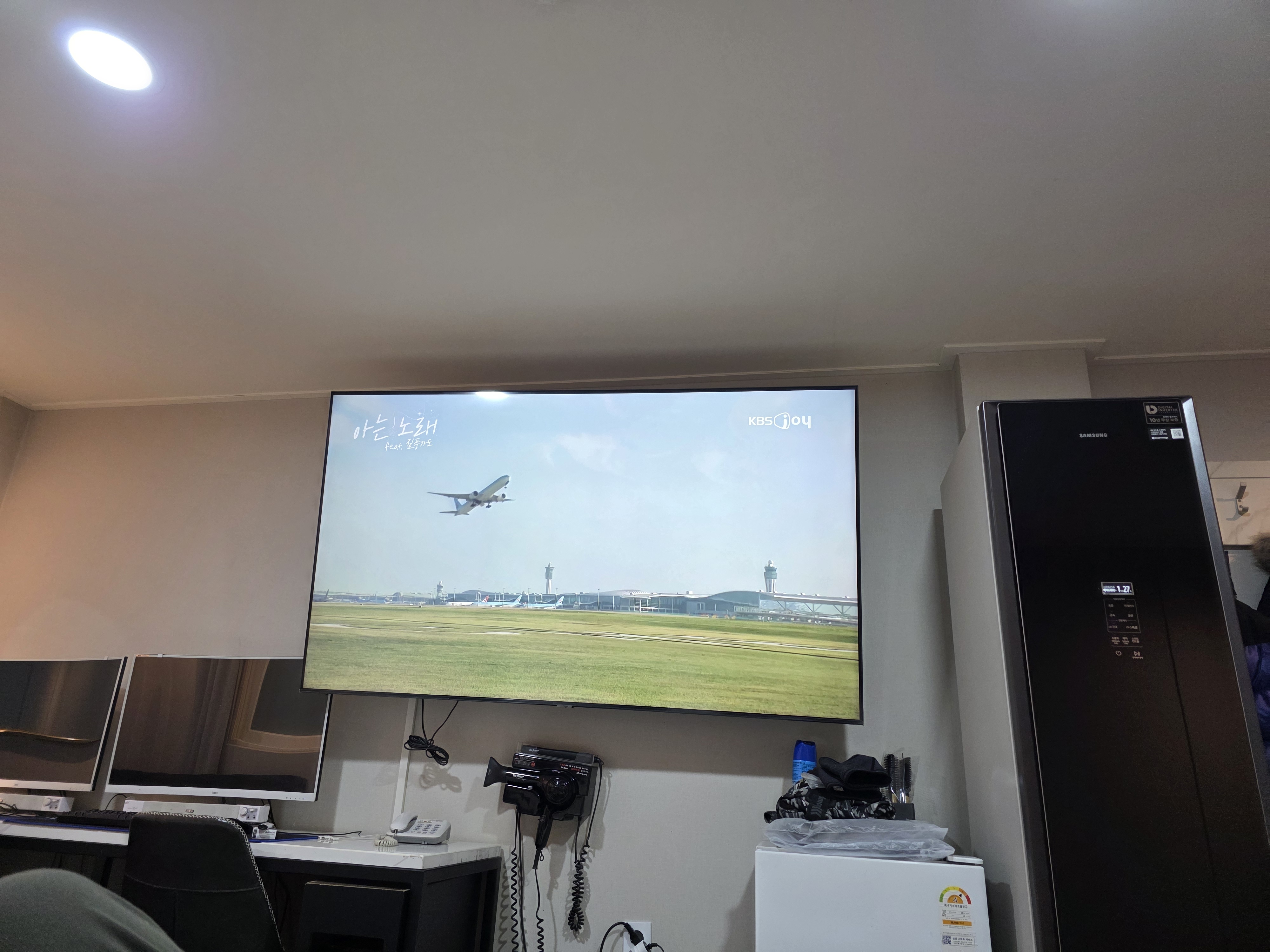 벽걸이 TV와 컴퓨터 모니터, 스타일러와 냉장고가 비치된 객실