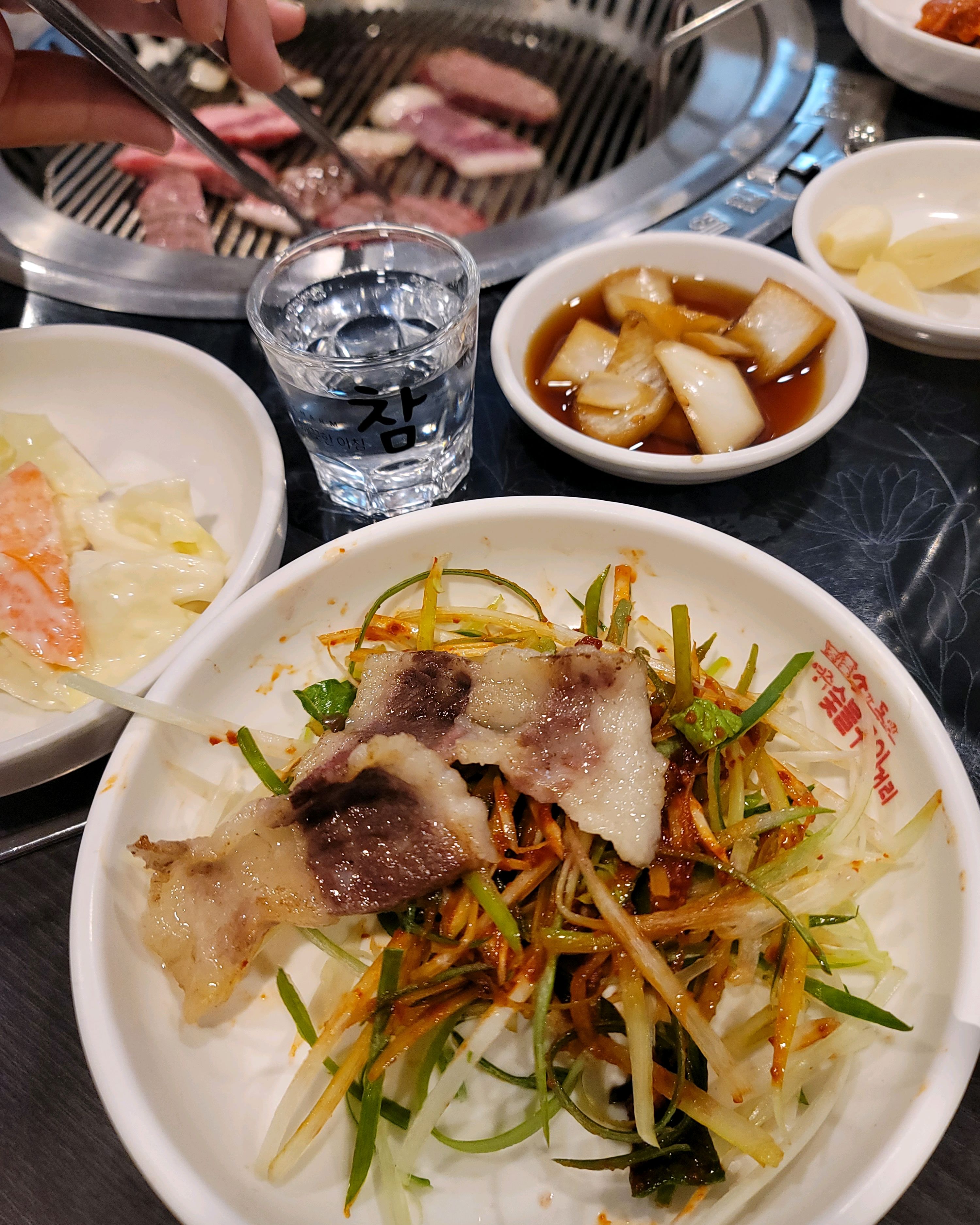 맛있게 익은 고기를 젓가락으로 집어 올리는 모습