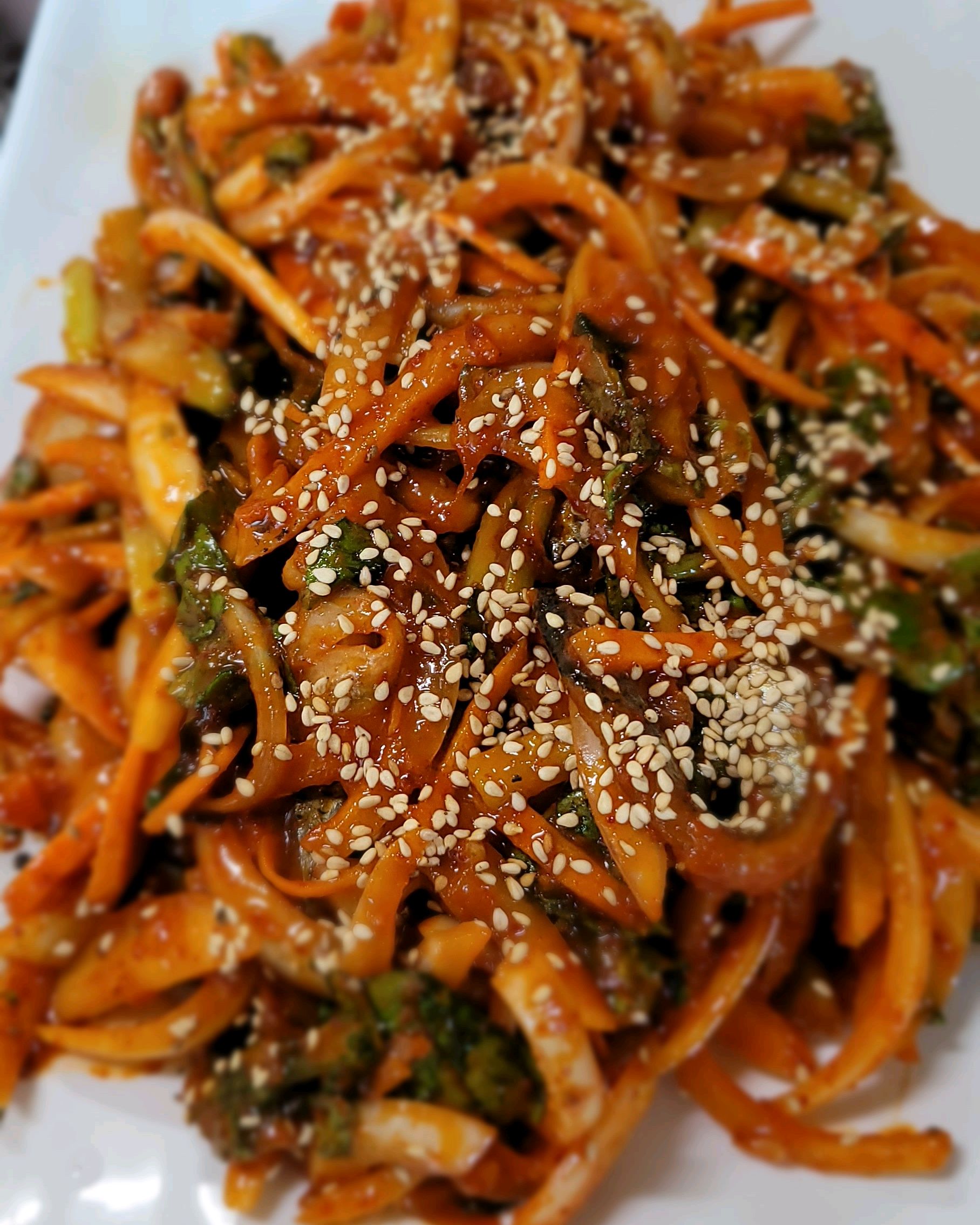 양념에 버무려진 채소와 고명이 듬뿍 올라간 요리