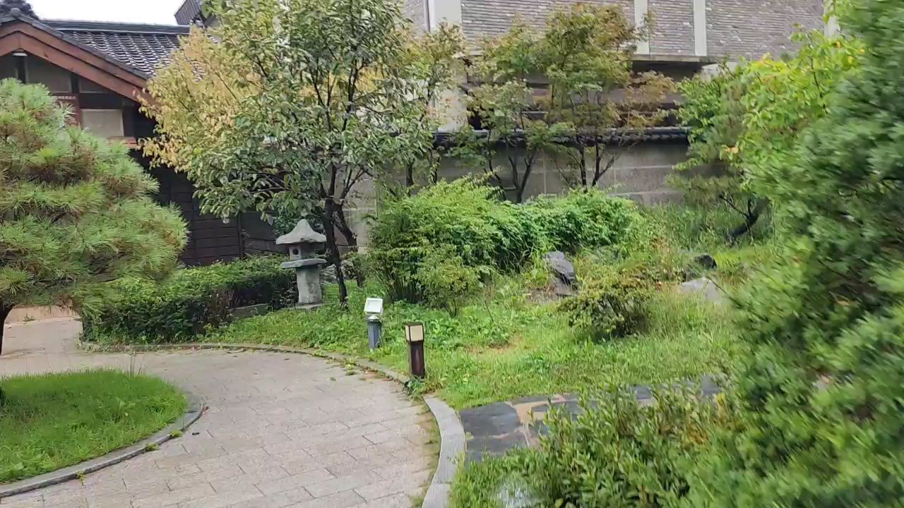 돌길과 석등, 나무와 수풀이 어우러진 정원과 외관 풍경입니다.