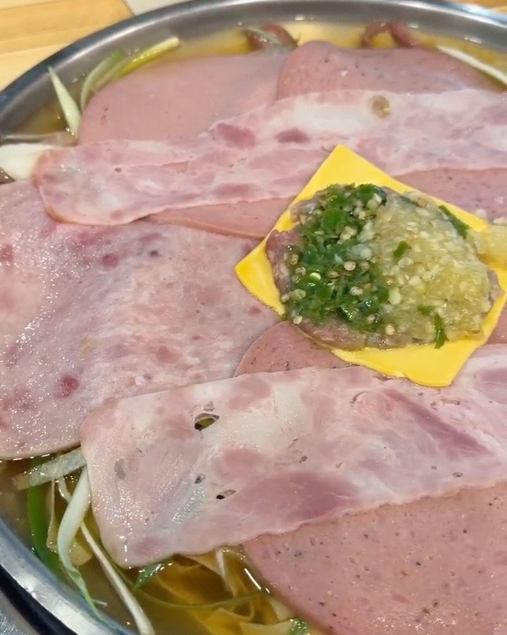 전골 냄비에 베이컨과 햄, 치즈, 다진 고추와 마늘이 담긴 모습