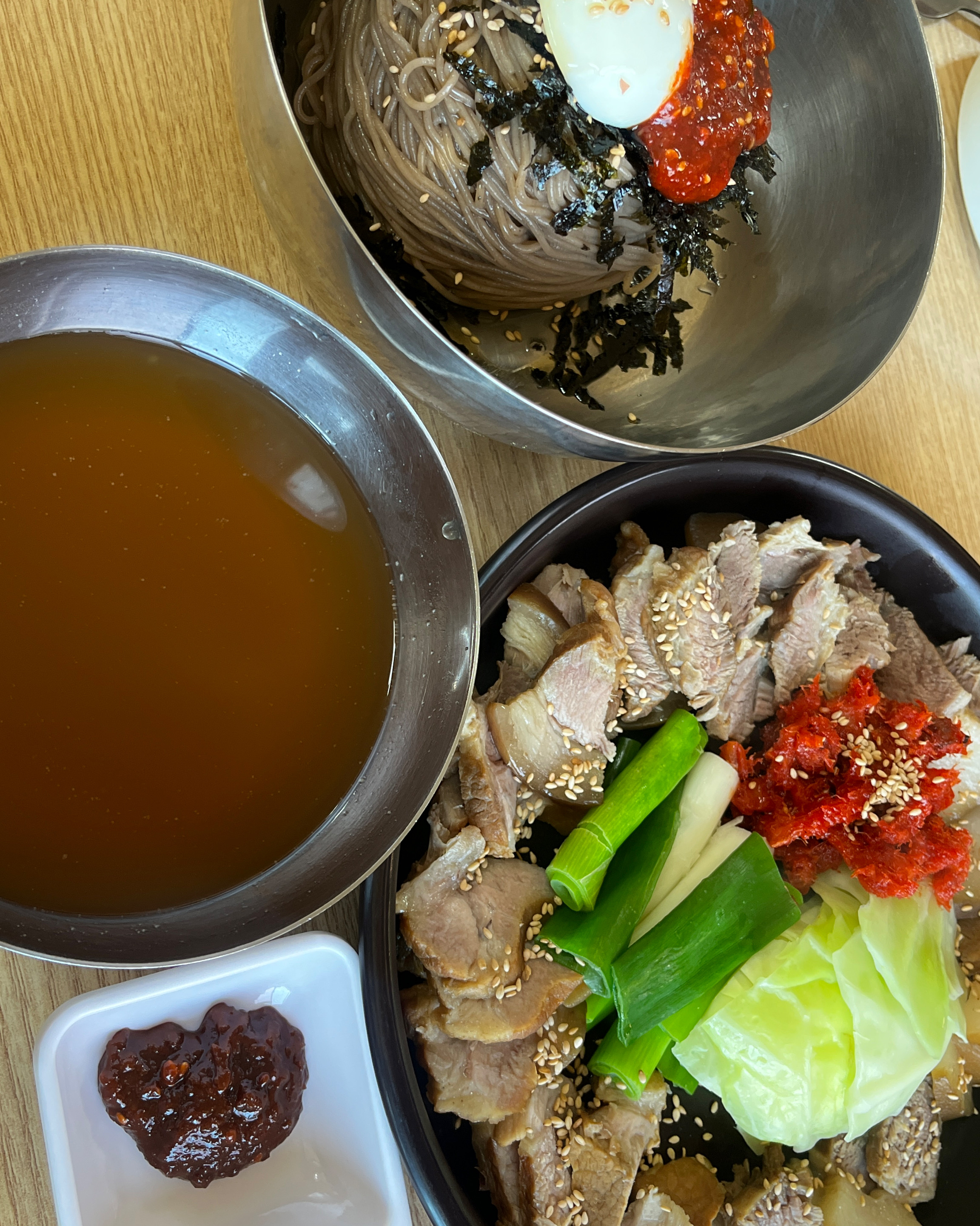 놋그릇에 담긴 막국수와 육수, 그리고 수육 한 접시