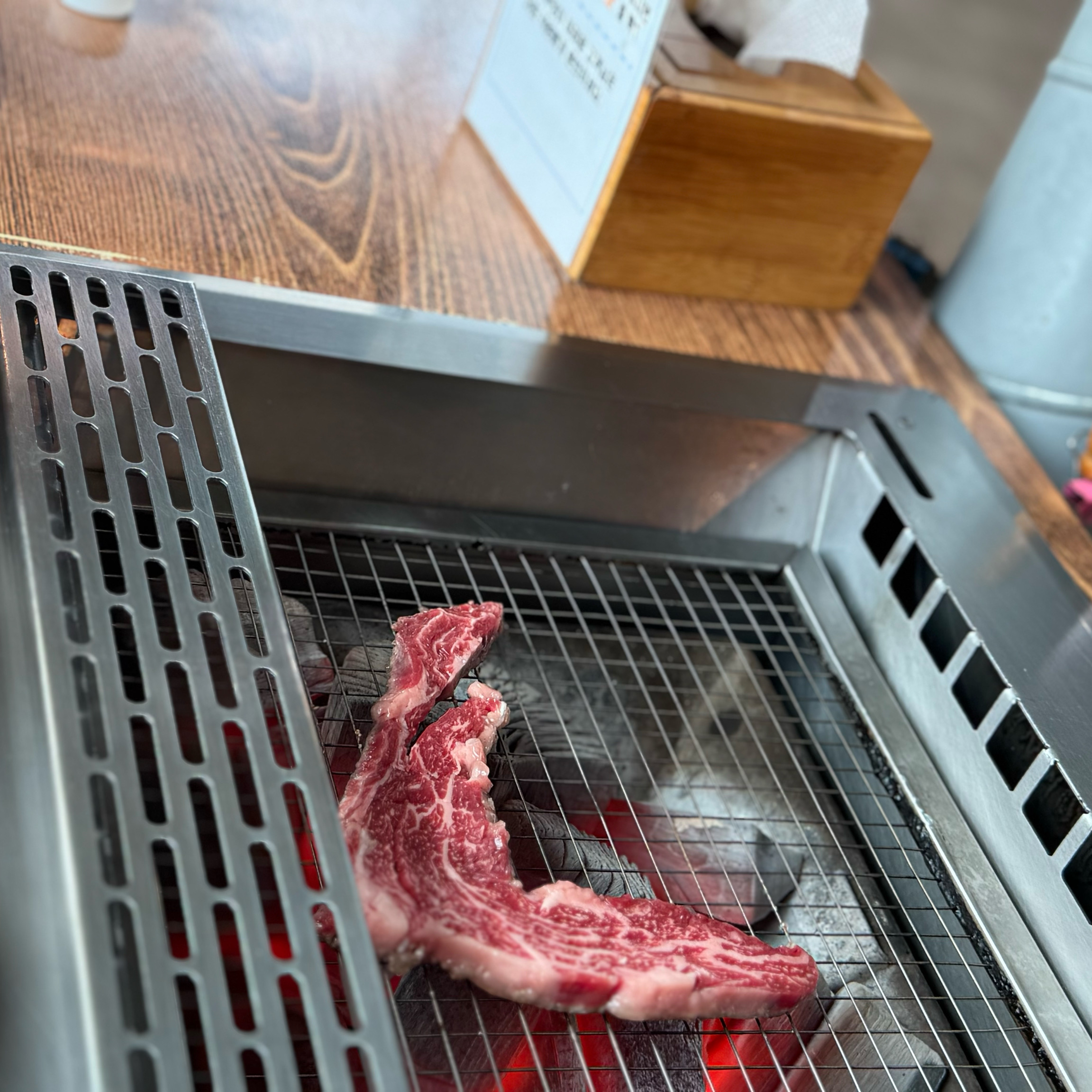 숯불 위에서 익어가는 두툼한 한우 스테이크