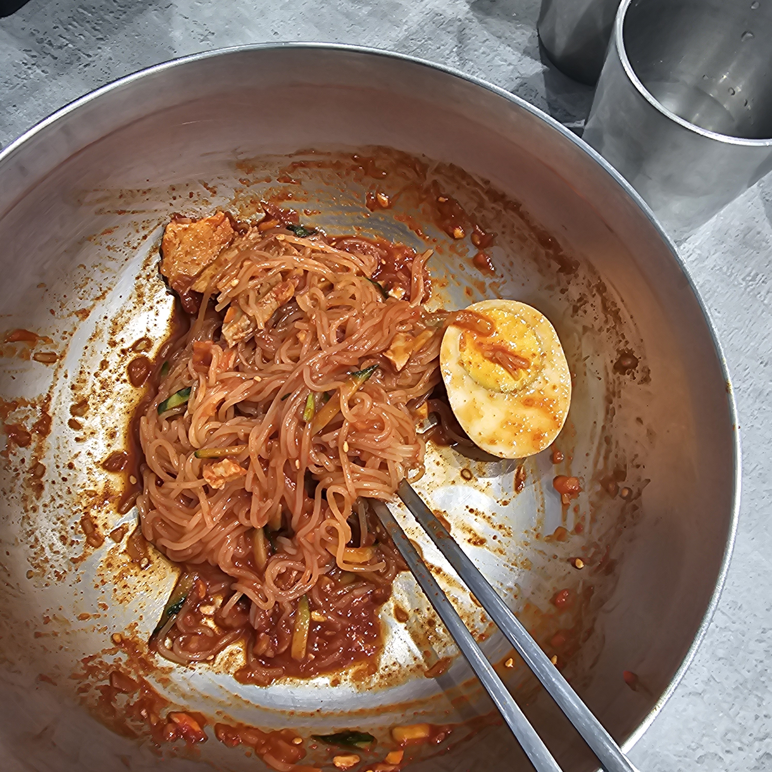 가위로 면을 자르고 있는 모습. 맛있게 밀면을 비벼 먹는 과정을 담고 있습니다.