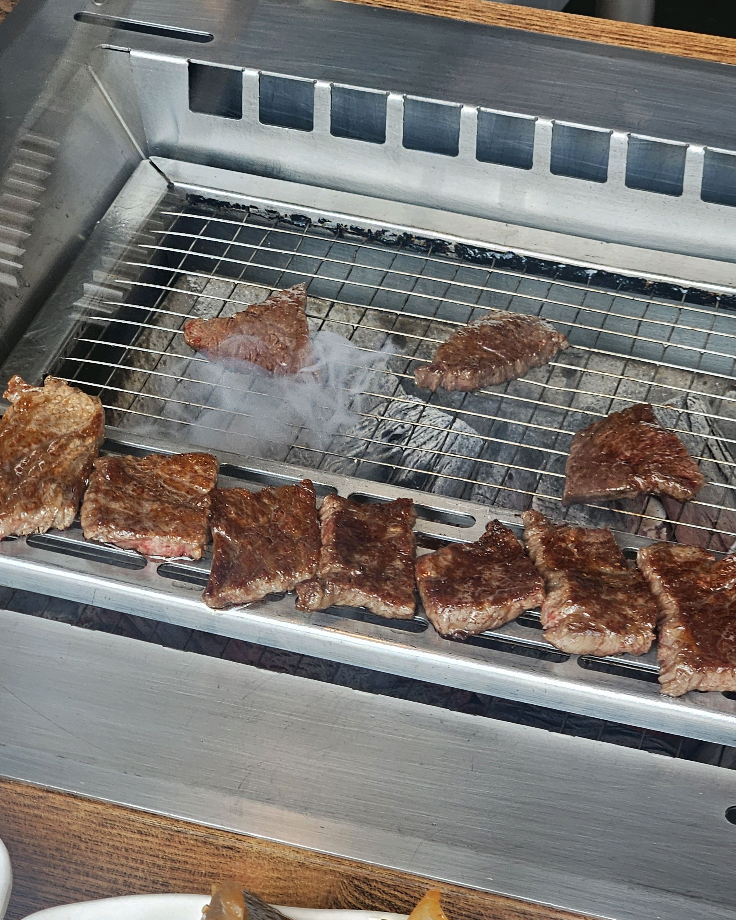 숯불 위에 구워지고 있는 여러 조각의 한우