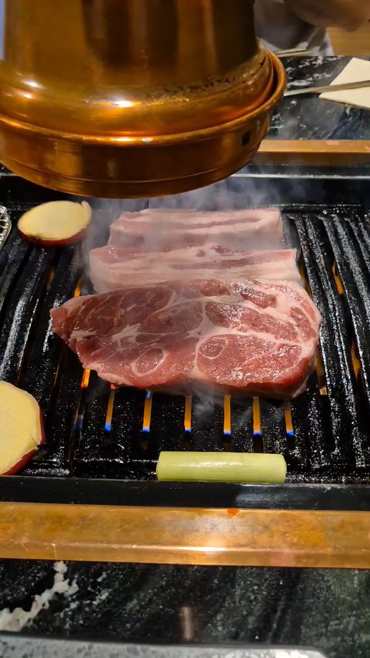 맛있게 구워진 고기를 젓가락으로 집는 모습