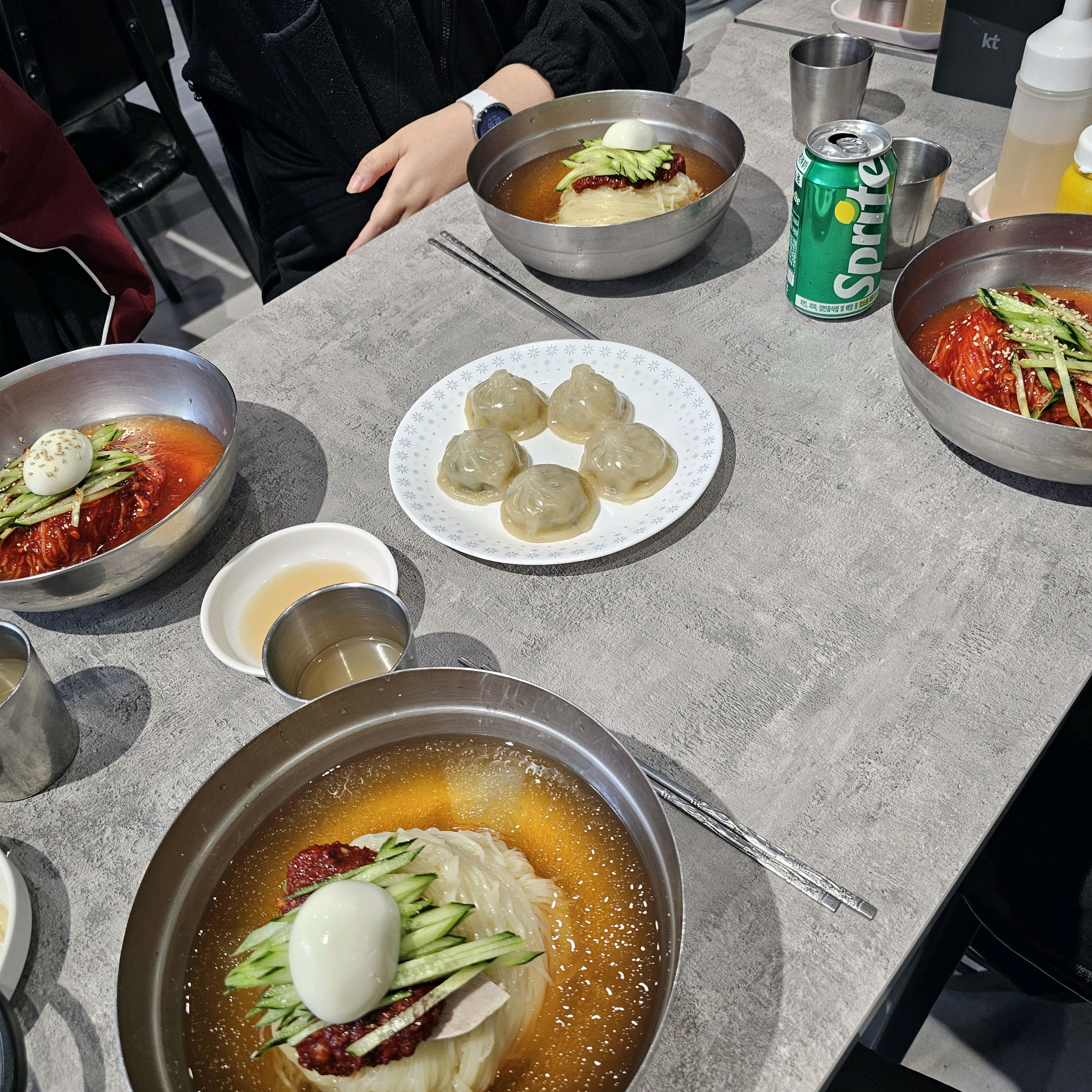테이블 위에 놓인 비빔밀면. 붉은 양념과 채소가 먹음직스럽게 보입니다.