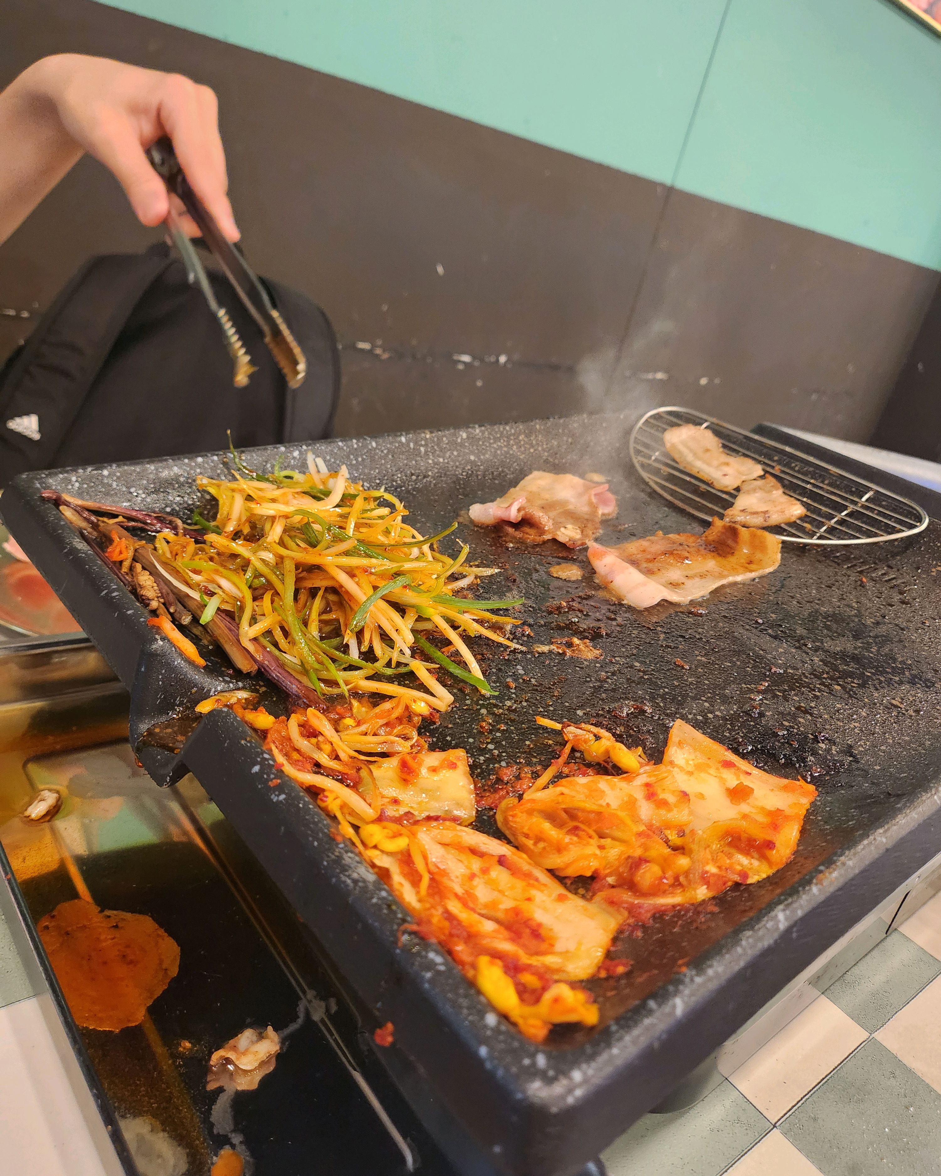 불판 위에서 익어가는 고기와 김치