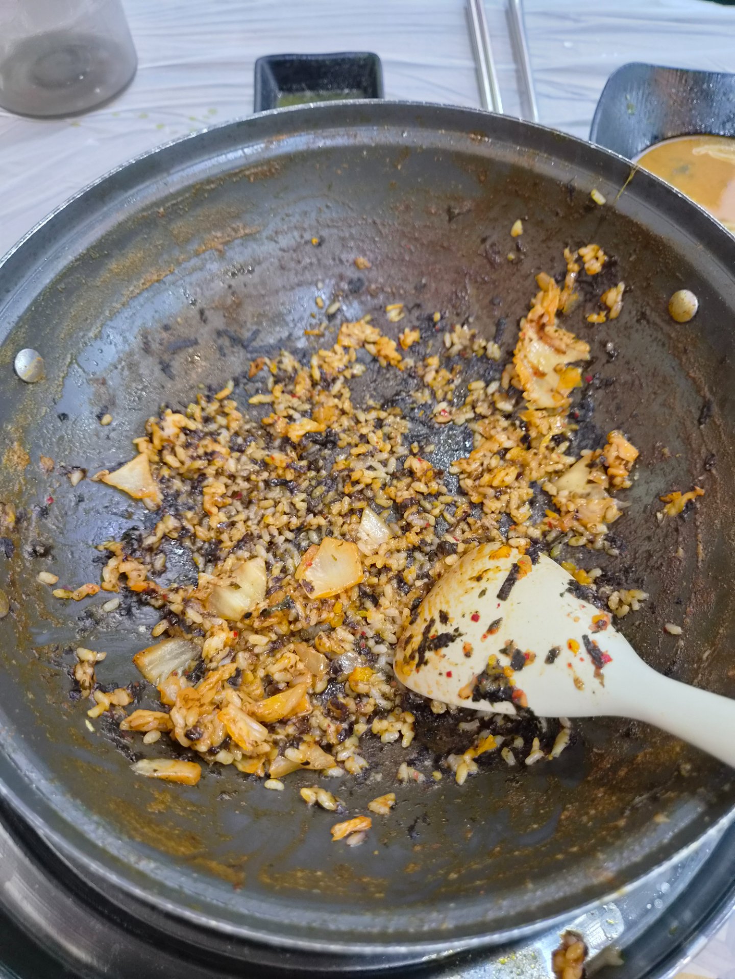 볶음밥을 볶은 팬의 모습, 밥알과 김치, 옥수수콘 등이 섞여 있음