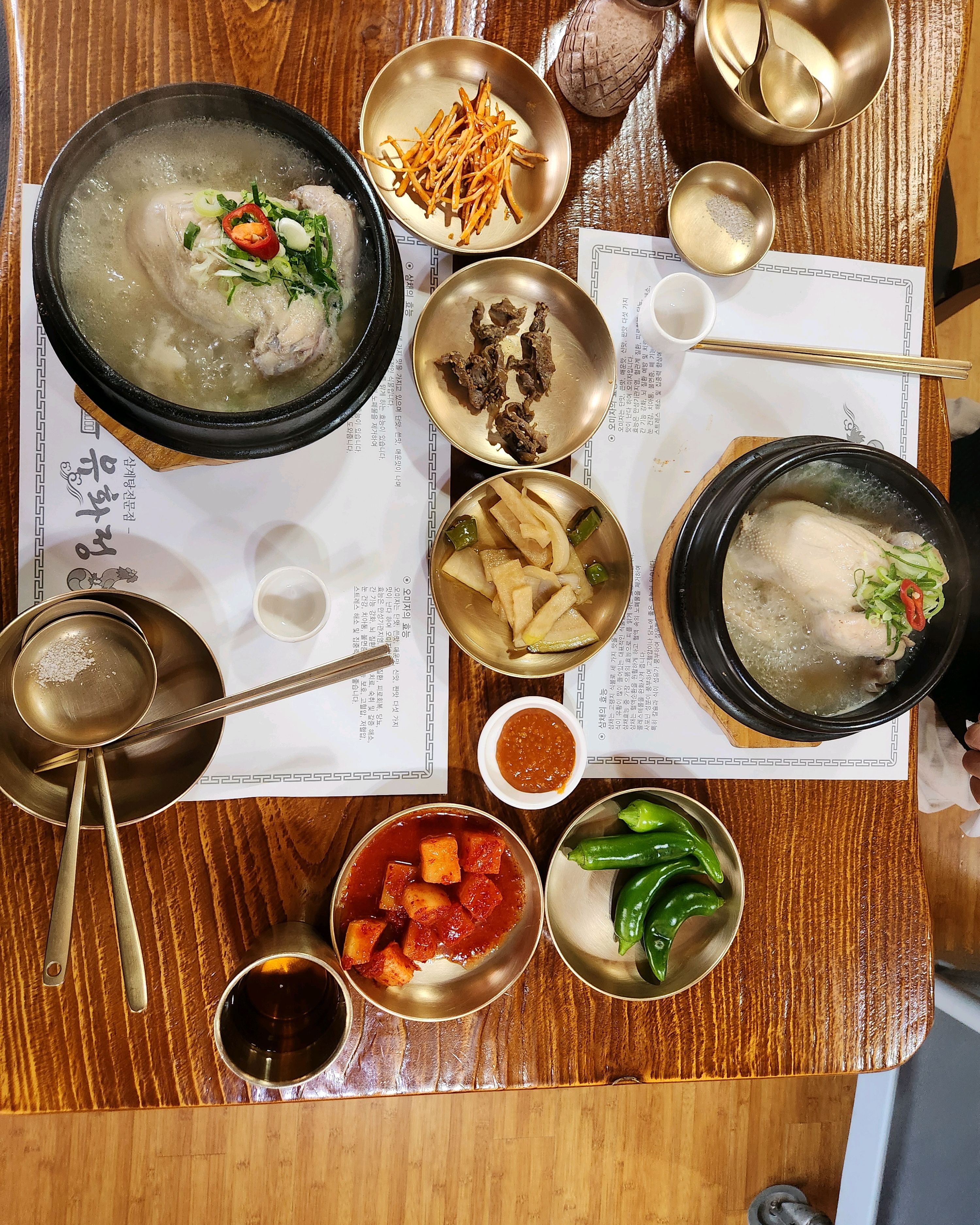 테이블 가득 차려진 삼계탕과 반찬들