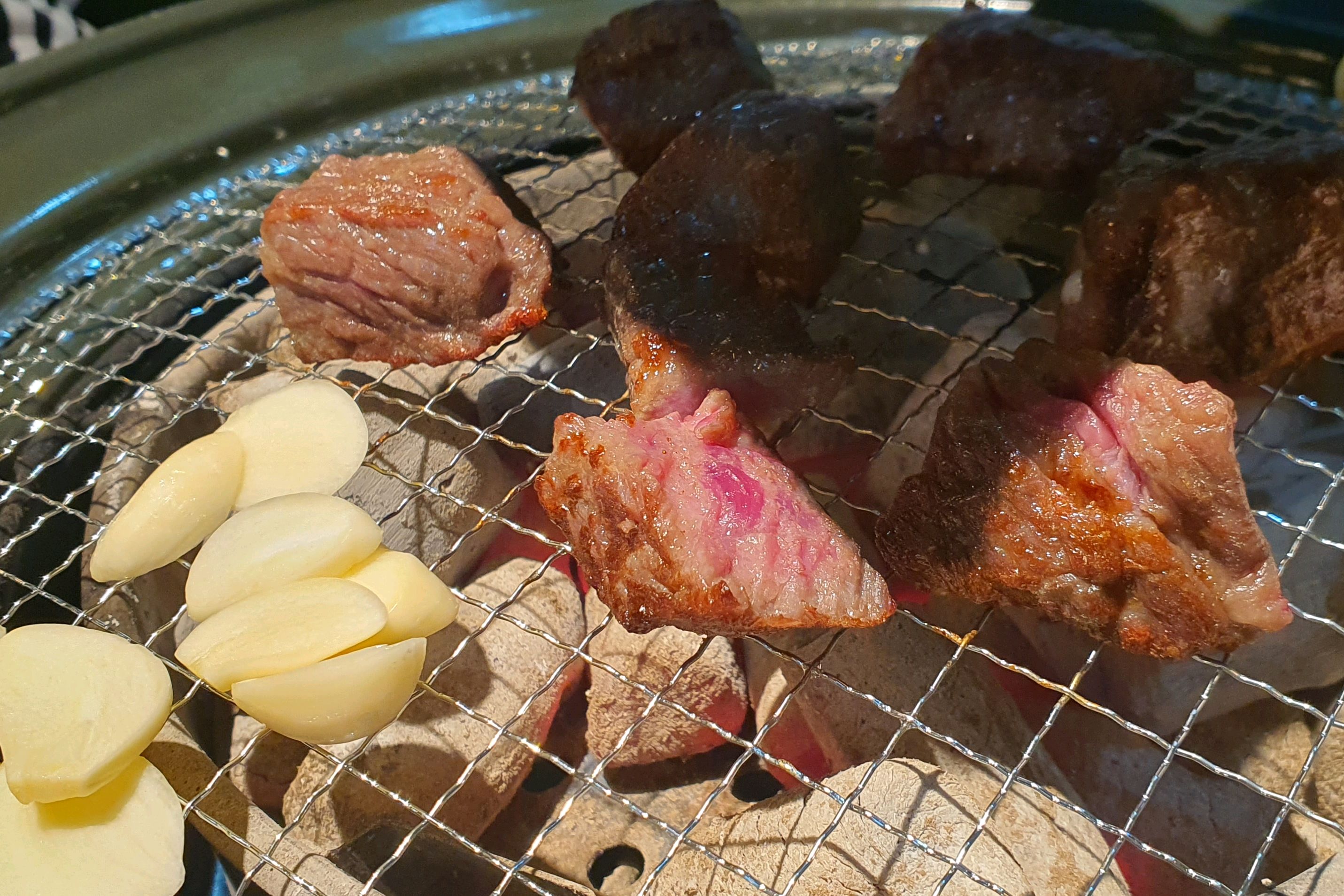 술병과 함께 놓인 숯불구이 고기