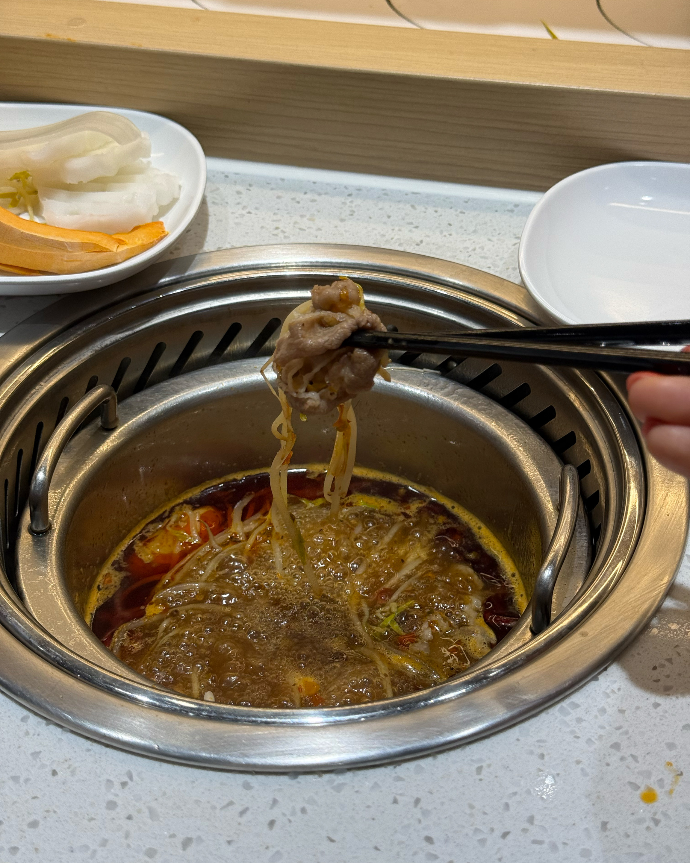 훠궈 국물에 찍어 먹기 위해 집어 올린 고기