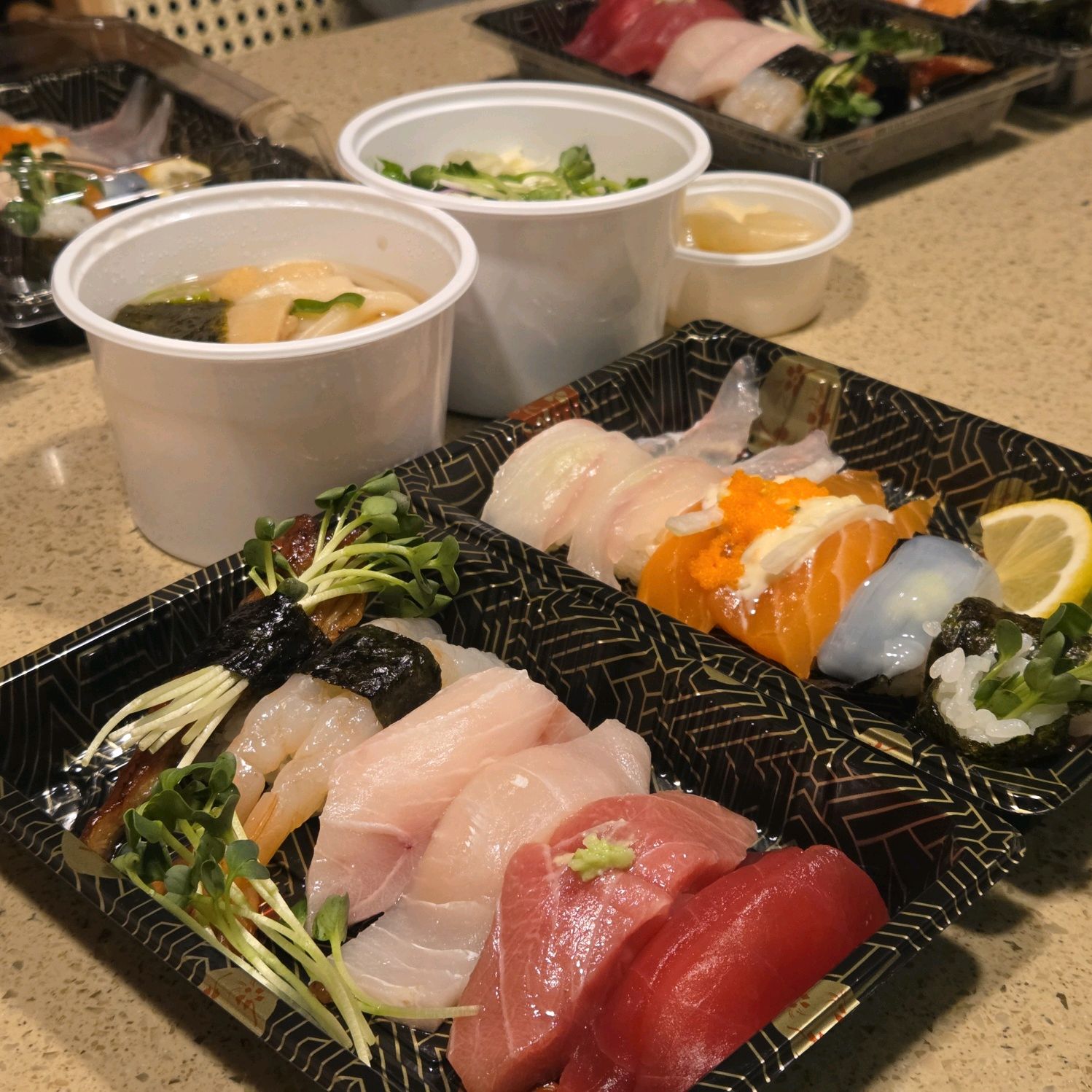 다양한 종류의 초밥과 곁들임 채소가 넓은 접시에 먹음직스럽게 담겨 있다.