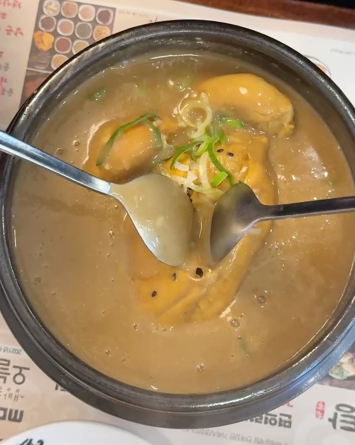 두 개의 숟가락으로 삼계탕을 뜨는 모습