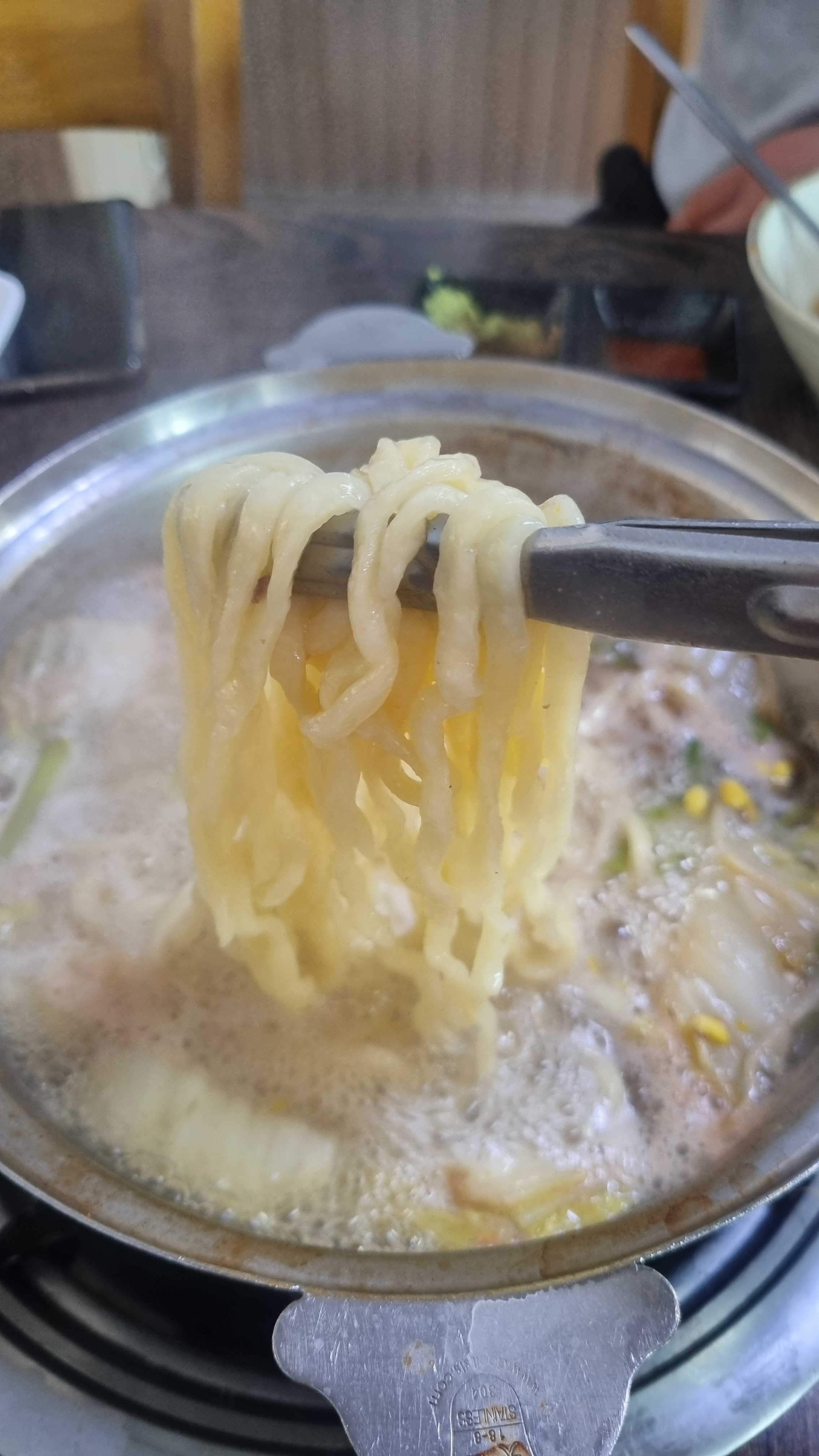 칼국수 면발을 집게로 집어 올리는 모습