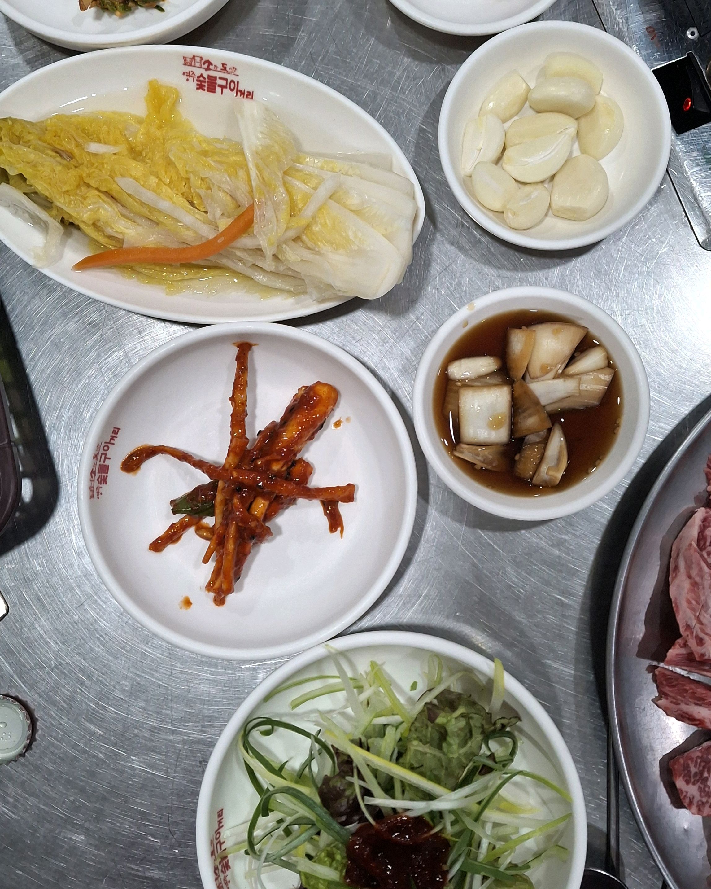 작은 접시에 담긴 붉은 양념의 젓갈과 콩나물 무침