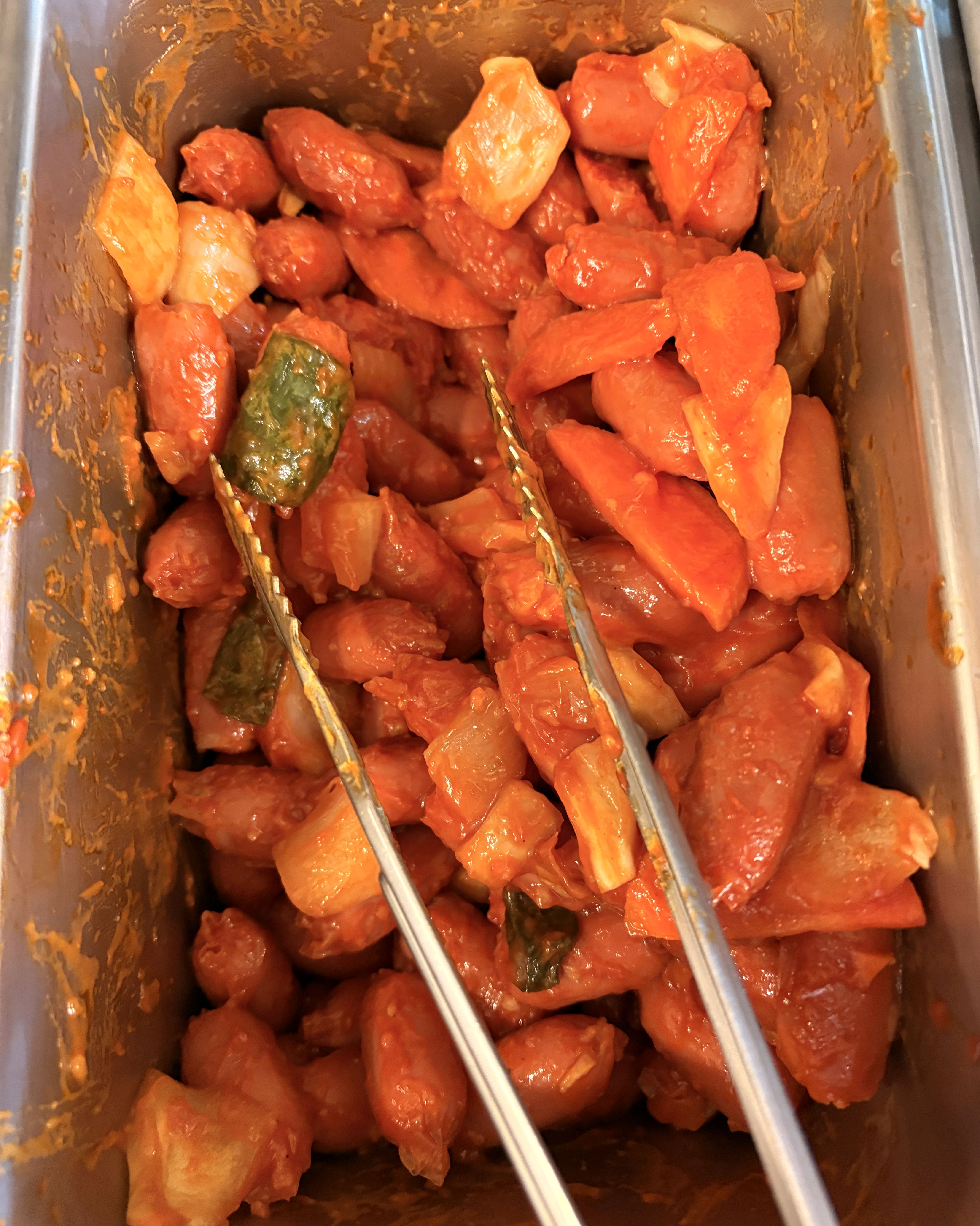 볶음 요리가 담긴 반찬 통에 집게가 담겨 있는 모습