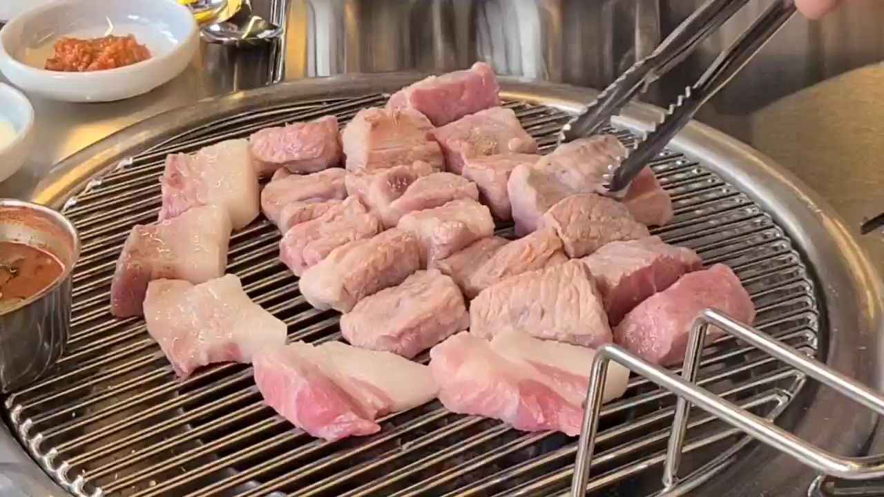 그릴 위에서 익어가고 있는 두툼한 흑돼지 조각들