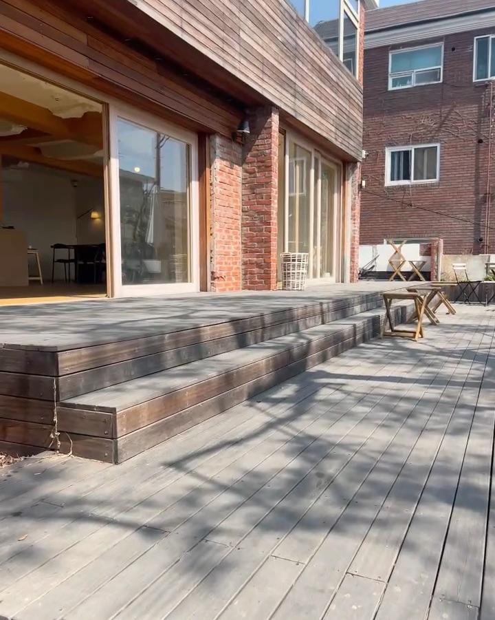 넓은 나무 데크와 테이블이 놓인 야외 공간